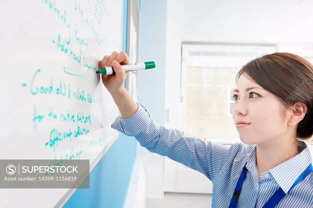 Woman writing on white board