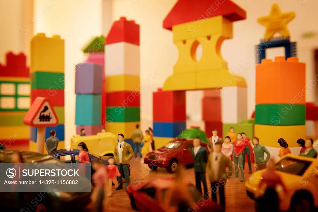 Toy cars and figurines in pretend plastic block town