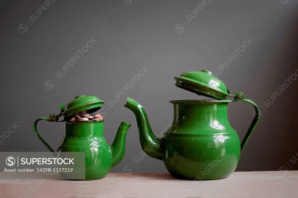 Two teapots with money inside