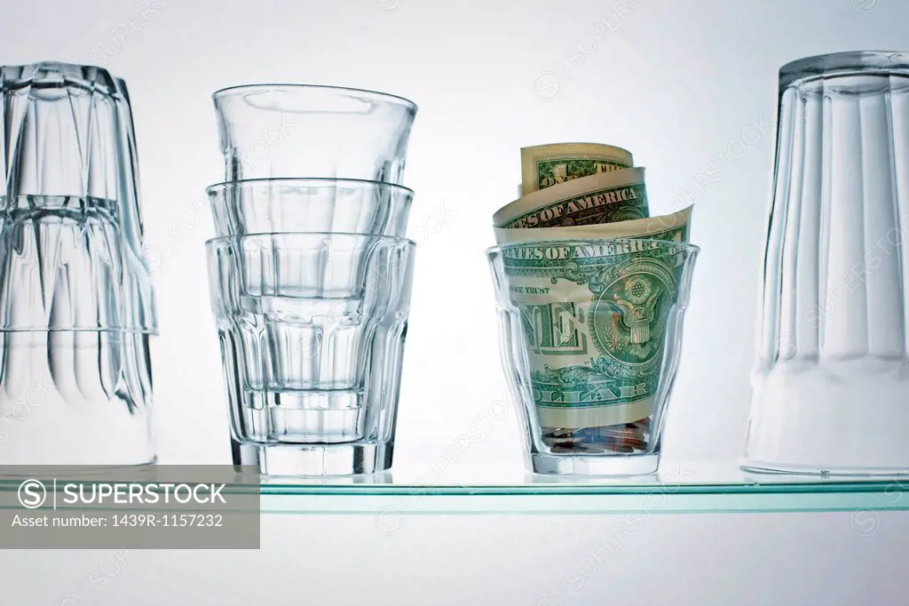 Dollar bills in glass on shelf