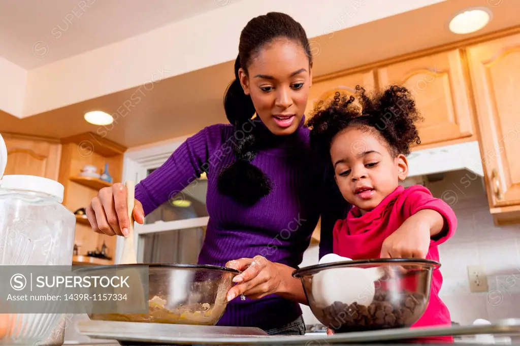 Mother and daughter mixing cookie dough