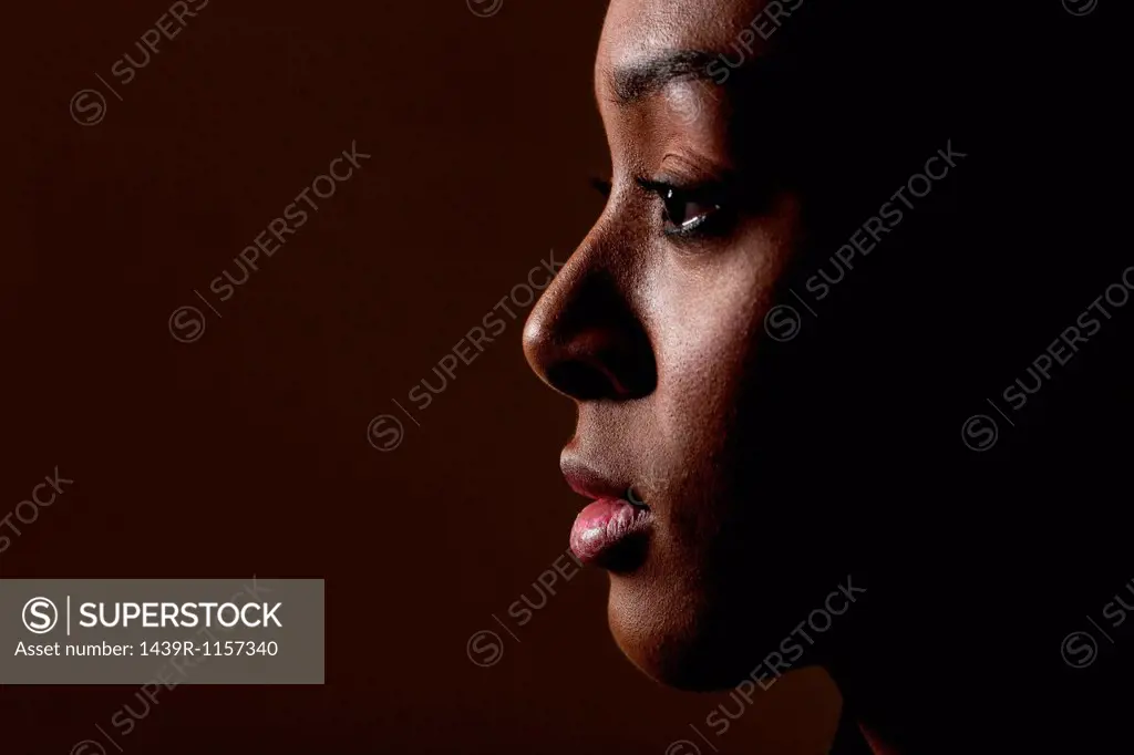 Side view of young woman on black background