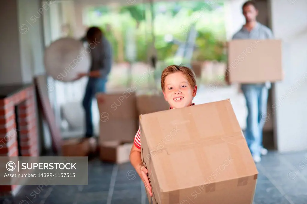 Boy moving house carrying cardboard box