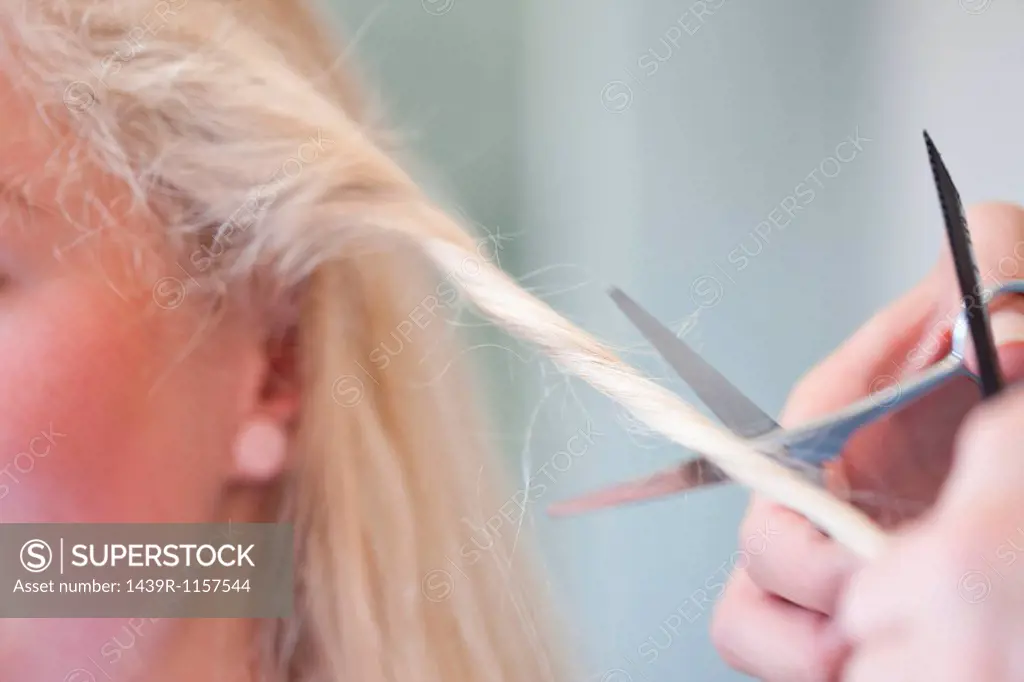 Young woman having haircut, close up