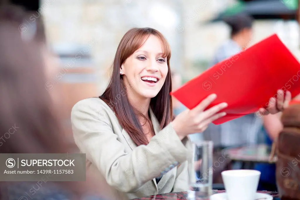 Young woman holding menu in cafe