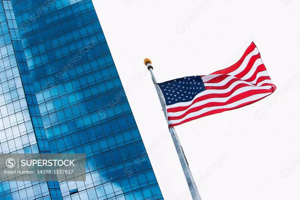 American flag flying by modern skyscraper