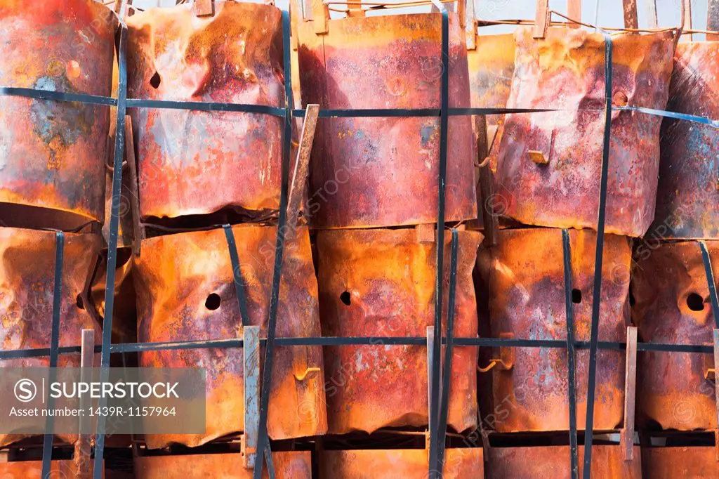 Stacked rusting barrels in a row