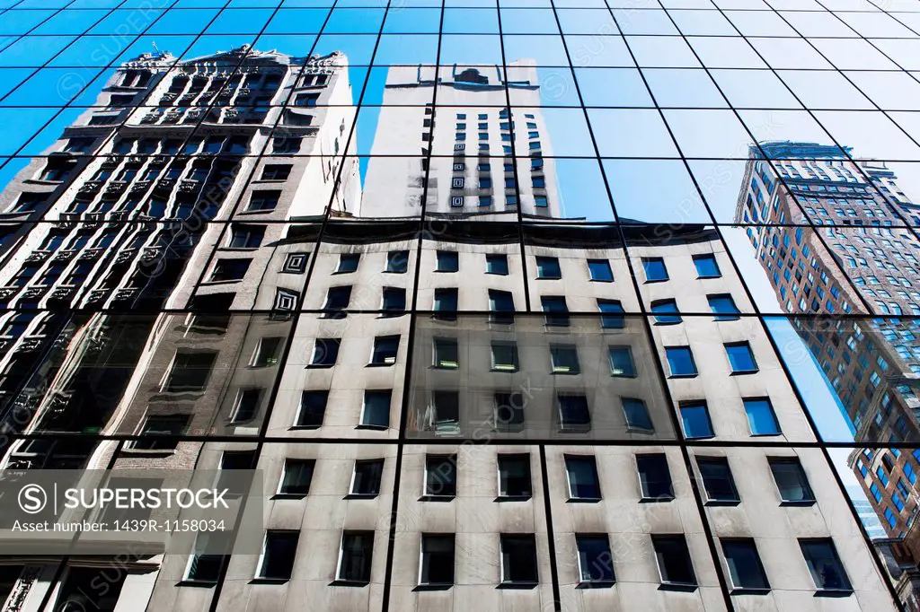 Office buildings reflected in modern glass facade