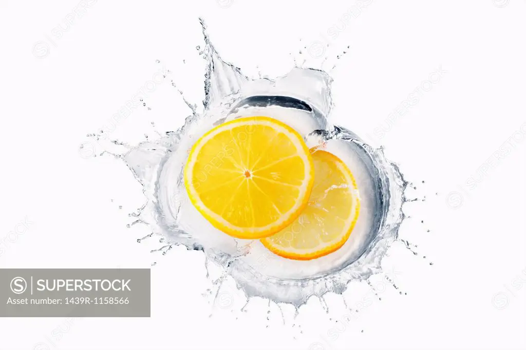 Two slices of lemon splashing in liquid