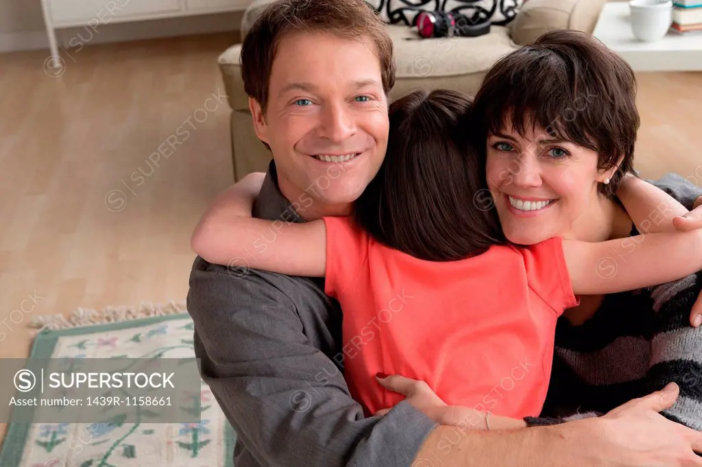 Parents hugging daughter