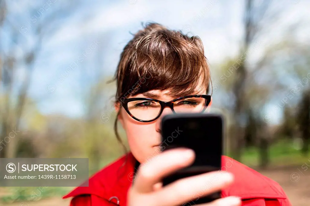Woman in city park looking at smartphone
