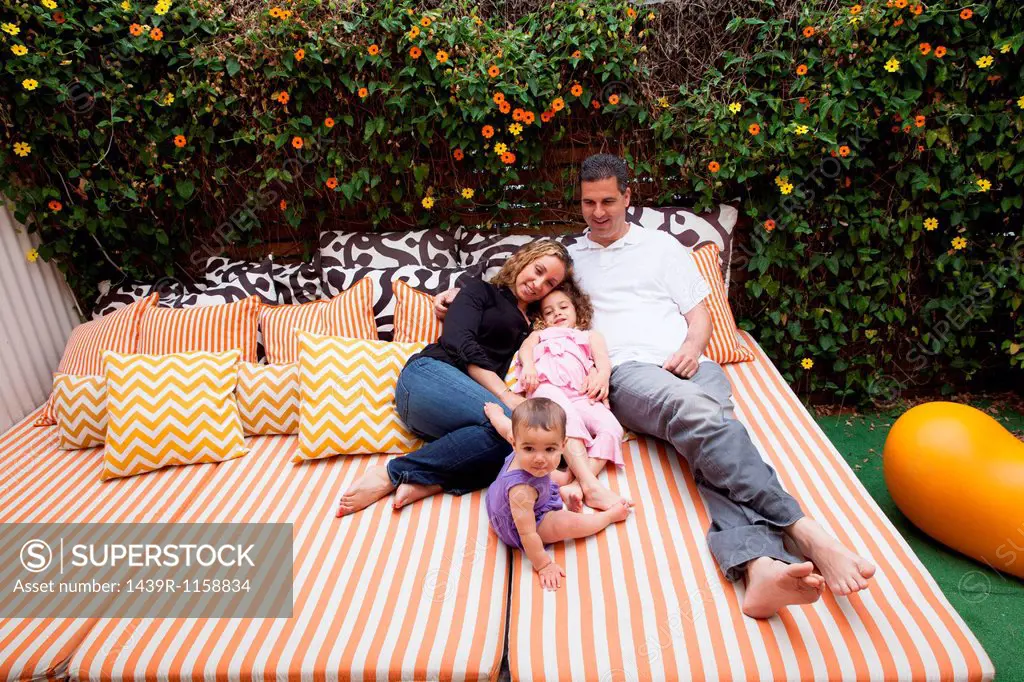 Family relaxing outdoors on cushions
