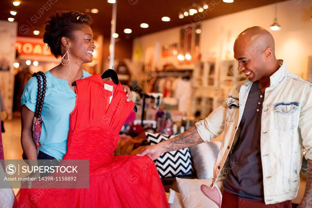 Young woman showing man red vintage dress
