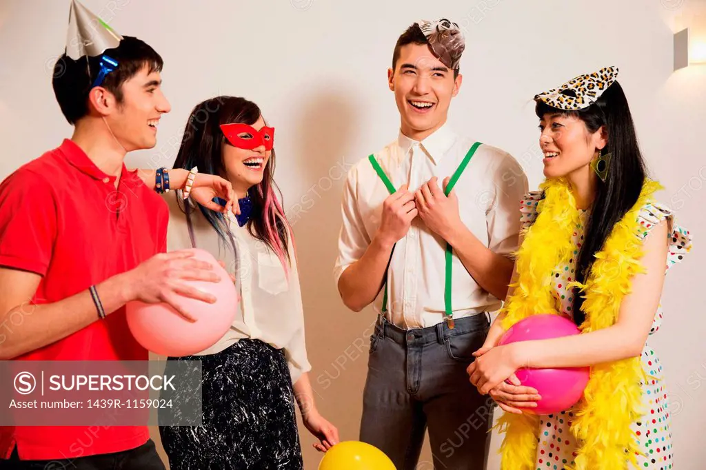 Friends at a party with balloons, studio shot