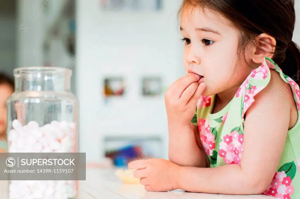 Close up of young girl tasting marshmallows