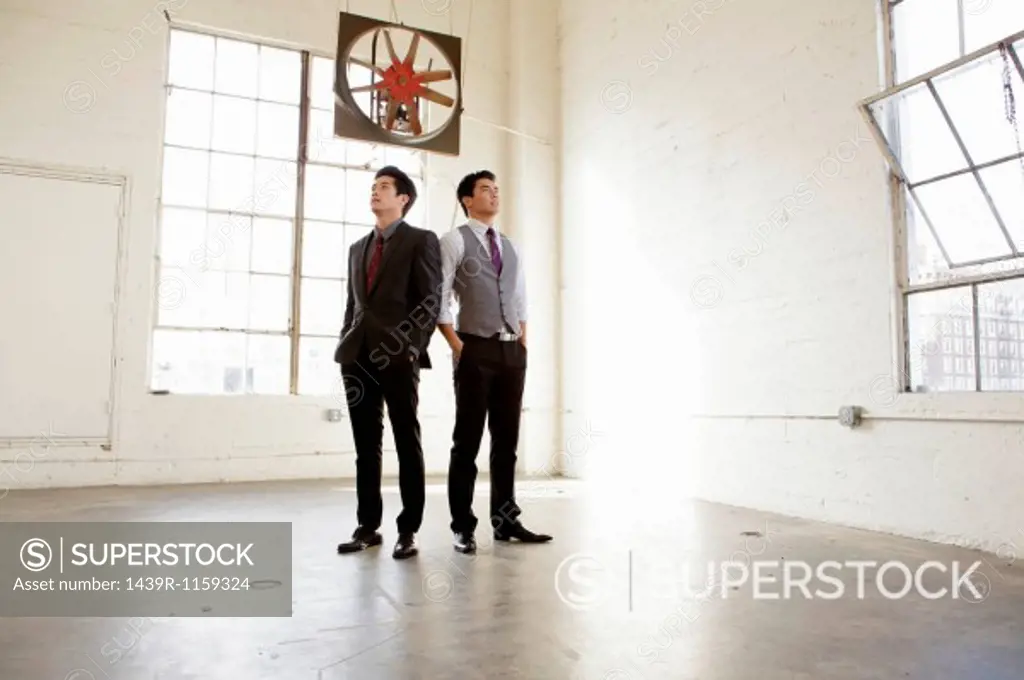 Two young business men inspecting empty office