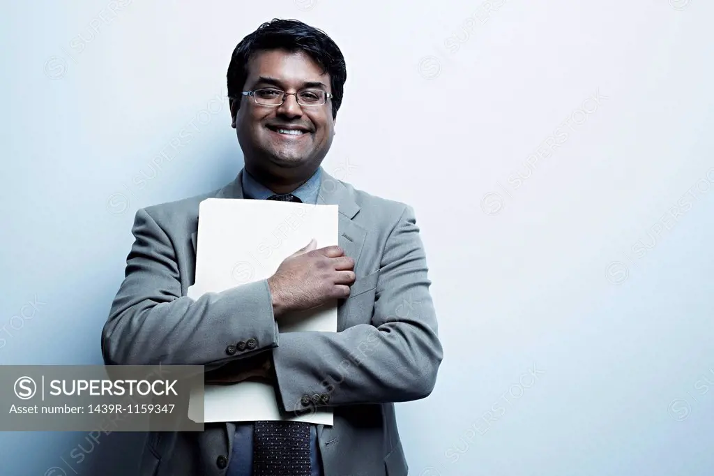 Studio portrait of businessman holding paperwork