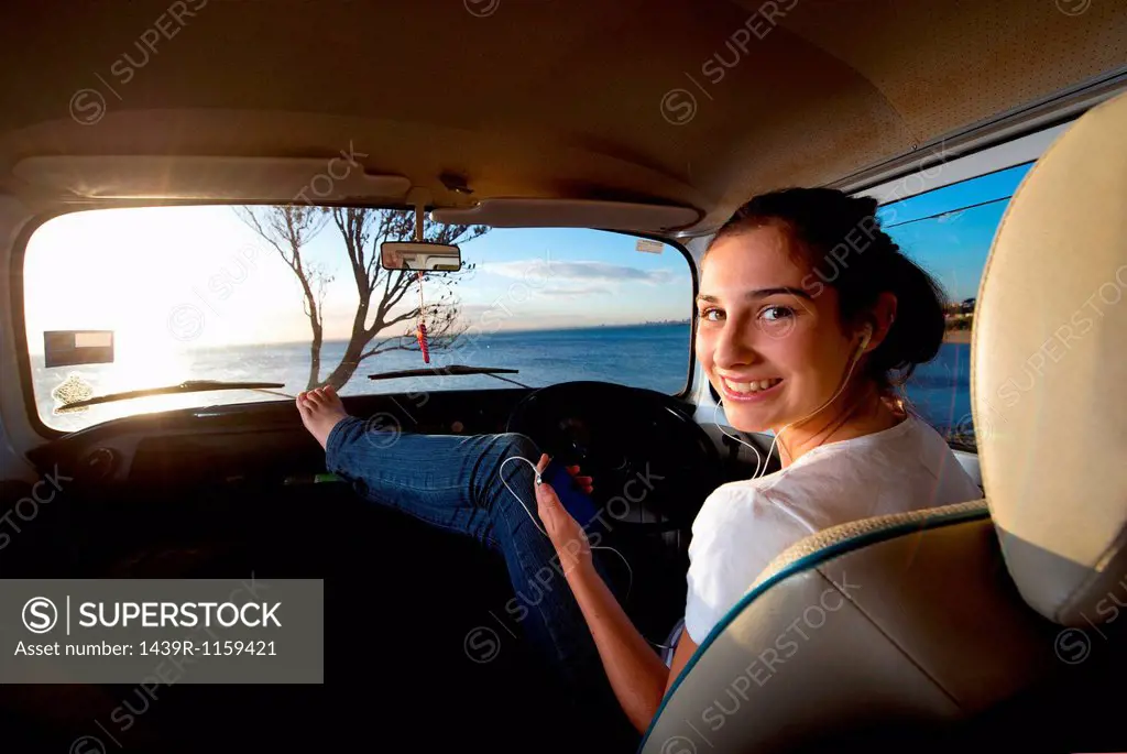 Young woman in camper van with feet up