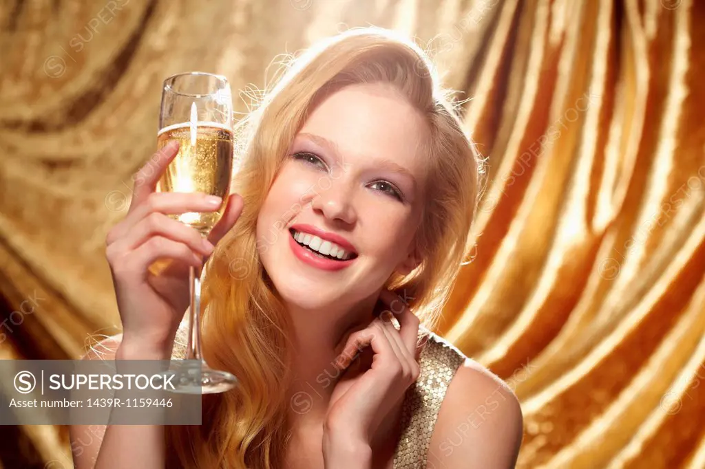 Candid portrait of young woman holding champagne flute