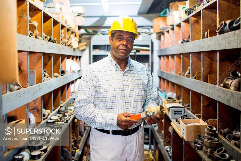 Portrait of man in plumbing stockroom with products