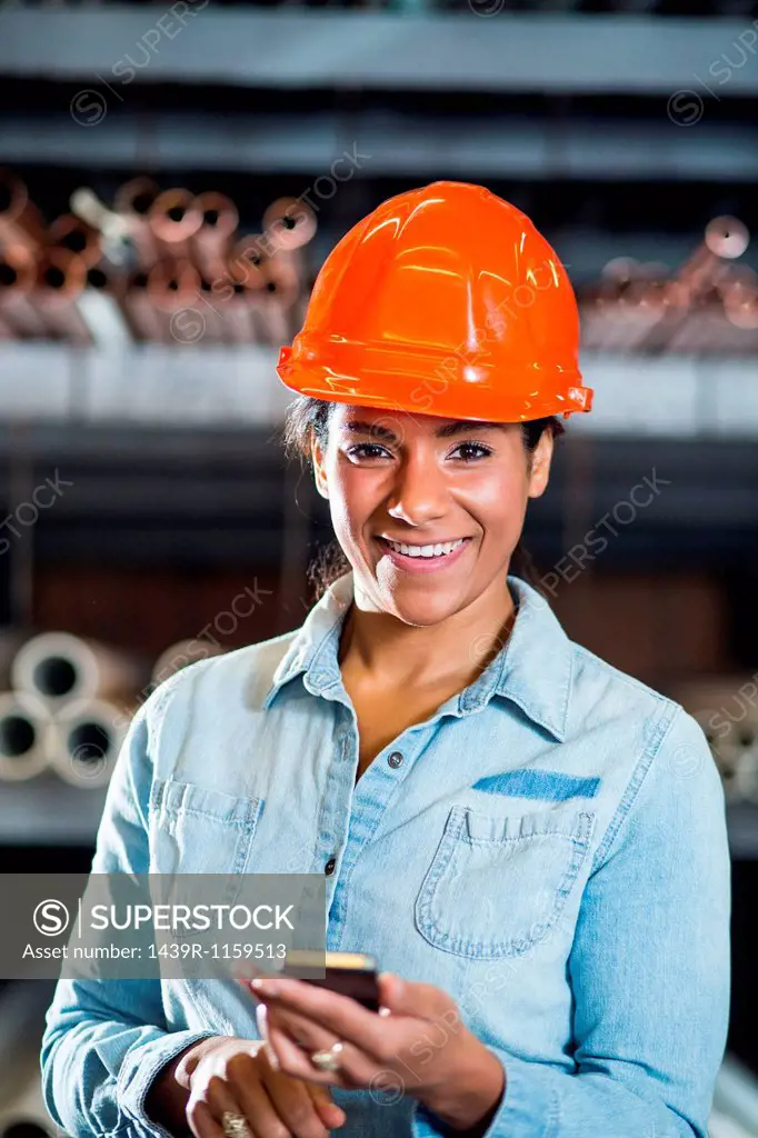Woman in warehouse holding smartphone