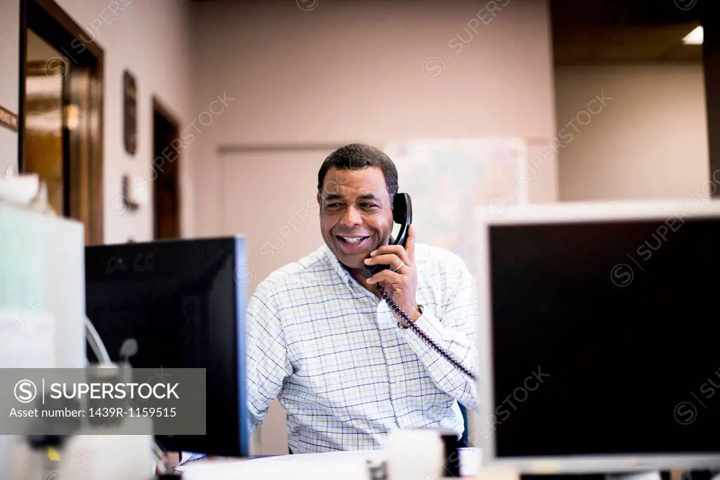 Mature man in office on landline
