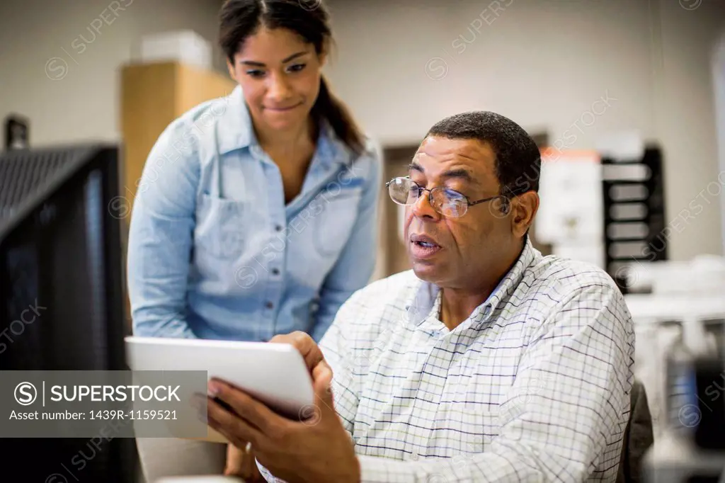 Office colleagues looking at digital tablet