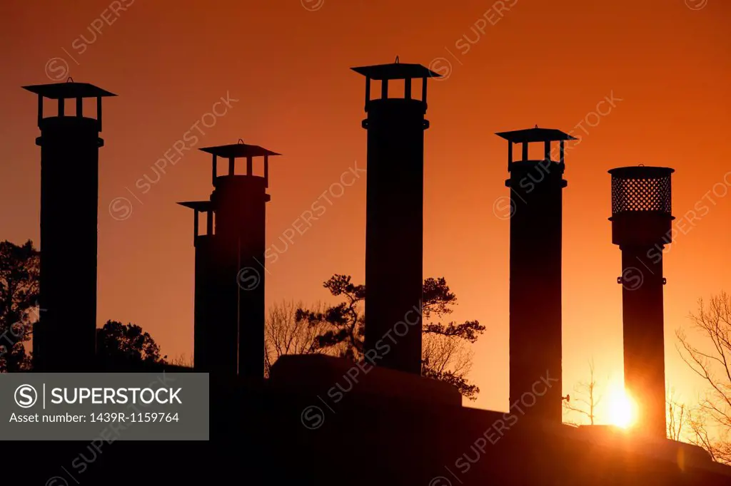 Silhouette of gas pipes in oil refinery at sunset