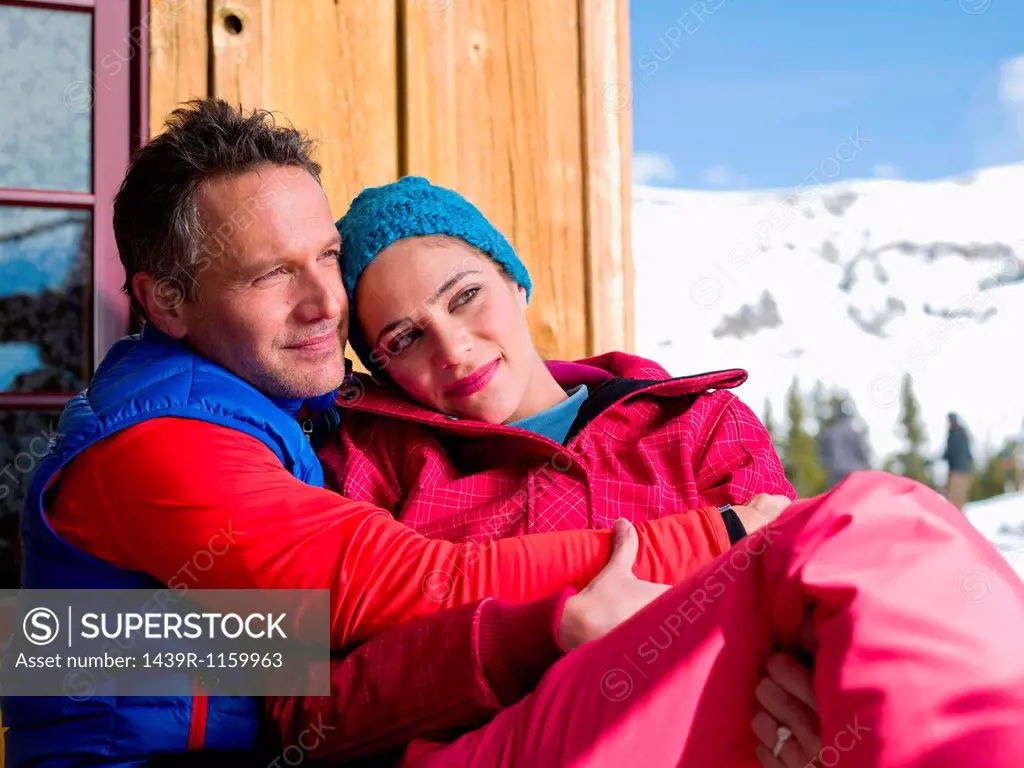 Mature man and young woman relaxing together at ski resort