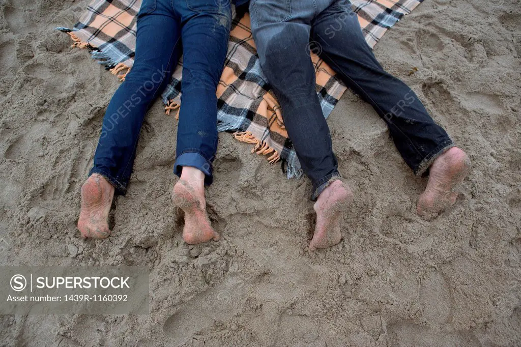 Mature couple lying on picnic blanket, high angle