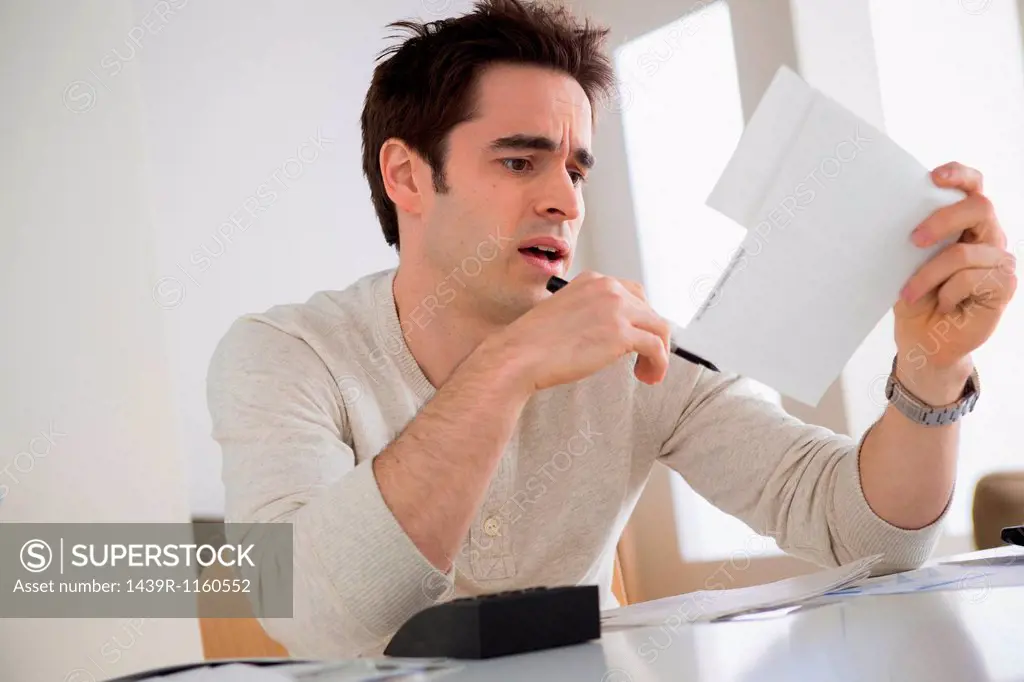 Worried looking man wearing holding document