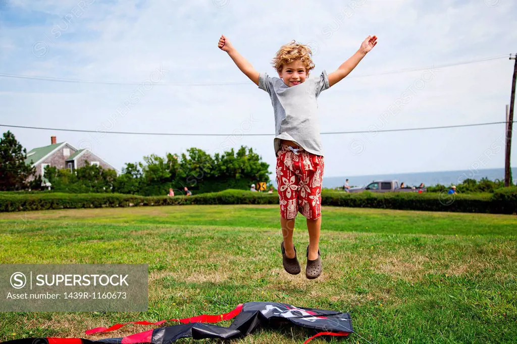 Boy jumping mid air in field