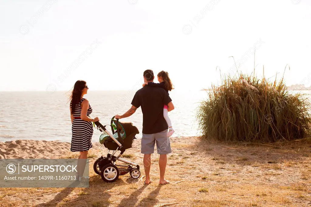Family standing on beach looking at sea
