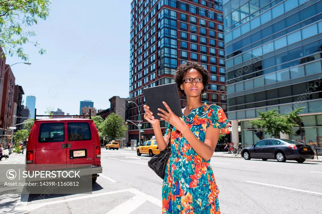 Woman on street parking bay holding digital tablet