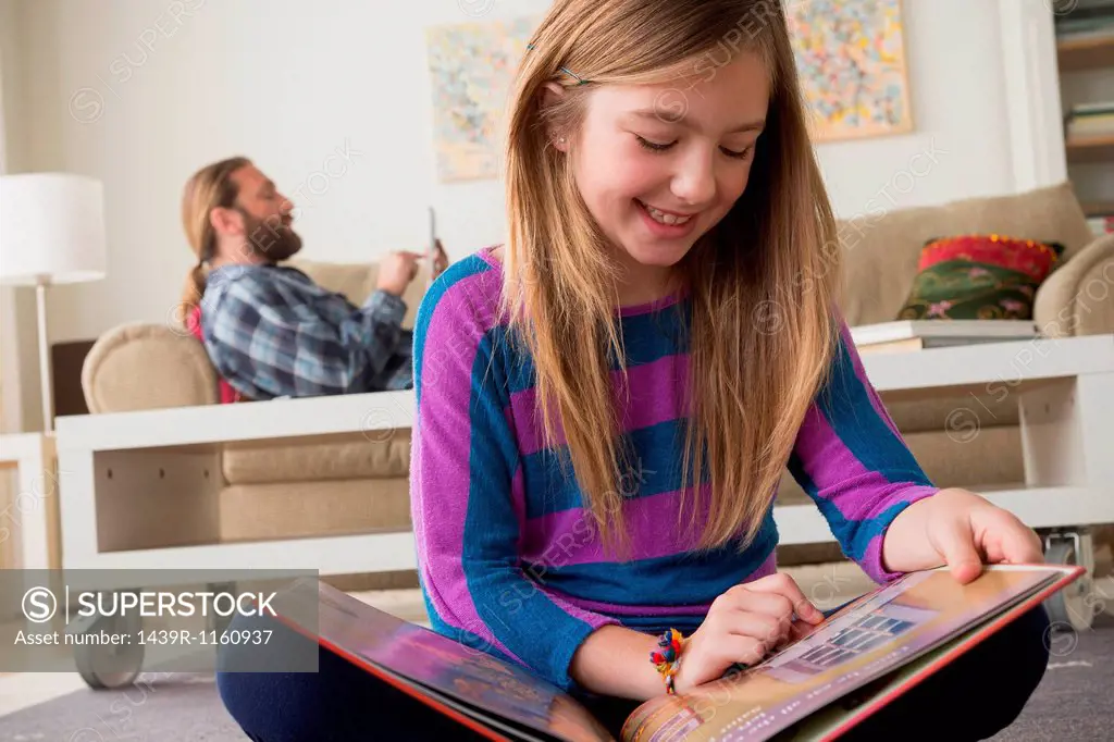 Girl smiling looking at pictures in book