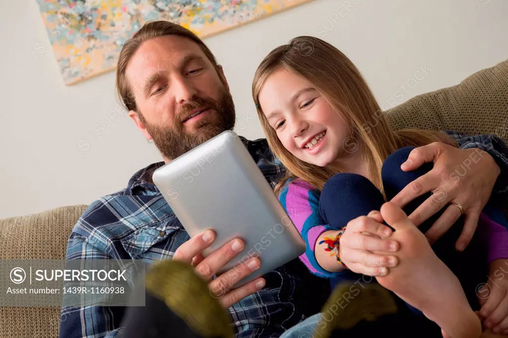Father and daughter looking at digital tablet