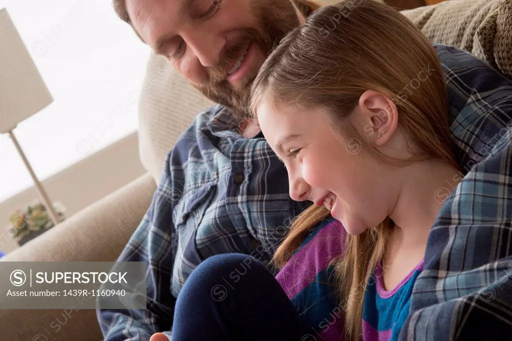 Father and daughter smiling on couch