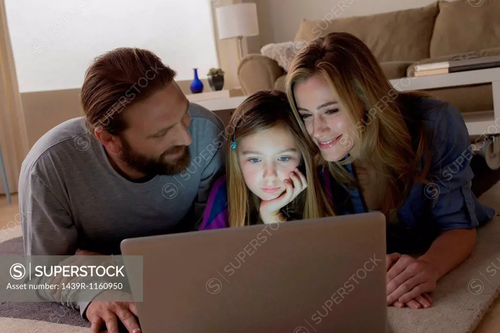 Parents and child looking at laptop