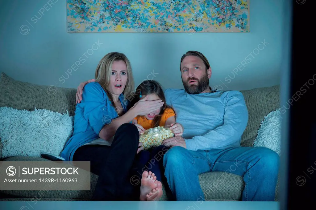 Parents and child watching horror movie