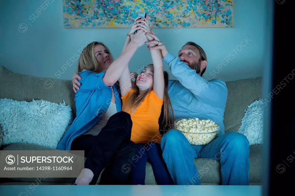 Parents and child fighting for remote control