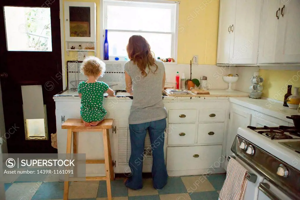 Mother and child at kitchen sink