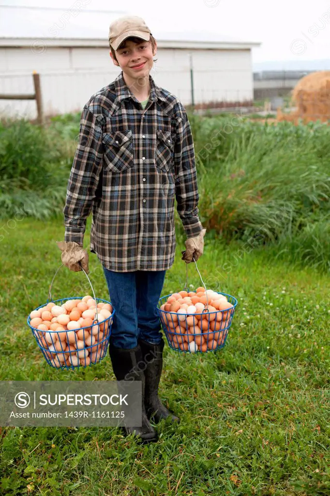 Boy carrying two baskets of eggs