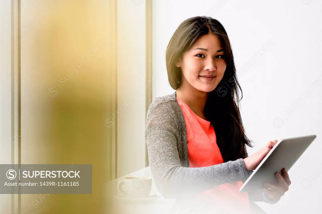 Woman looking up from digital tablet