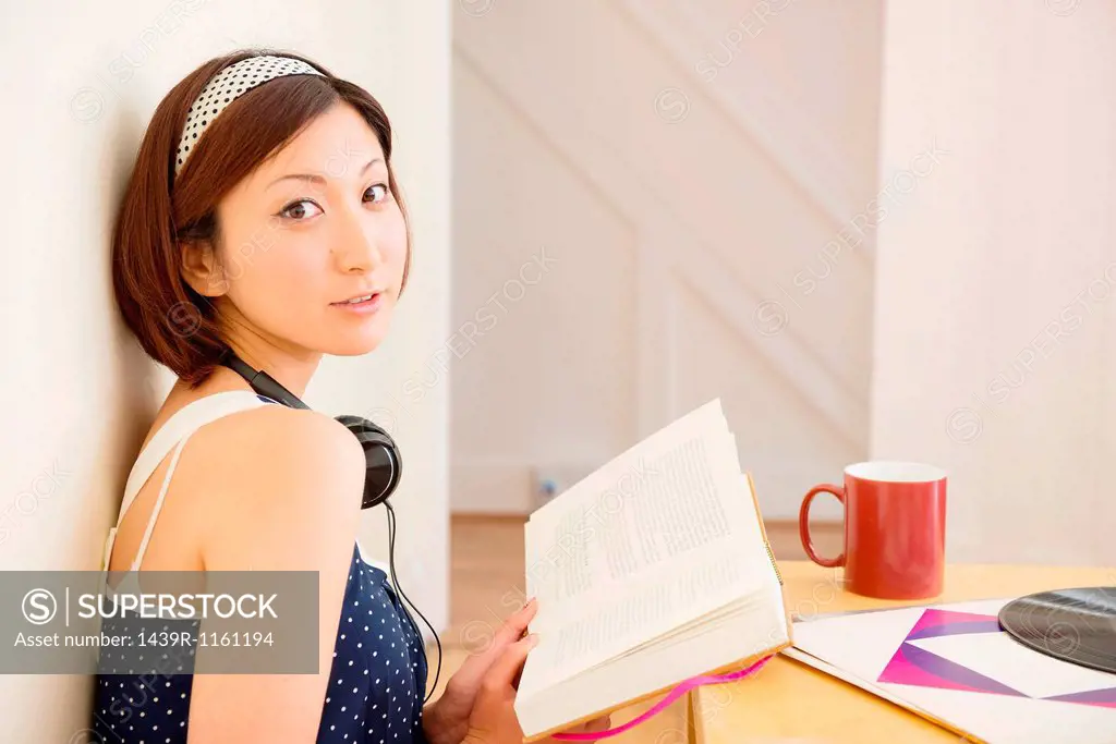 Woman looking up from book