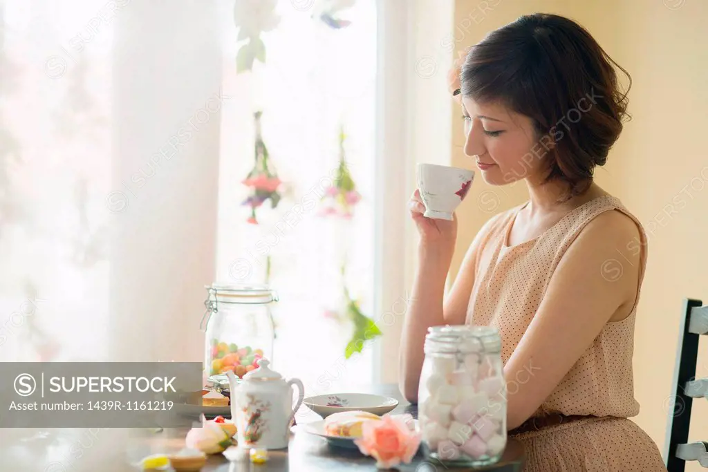 Woman looking down at tea cup