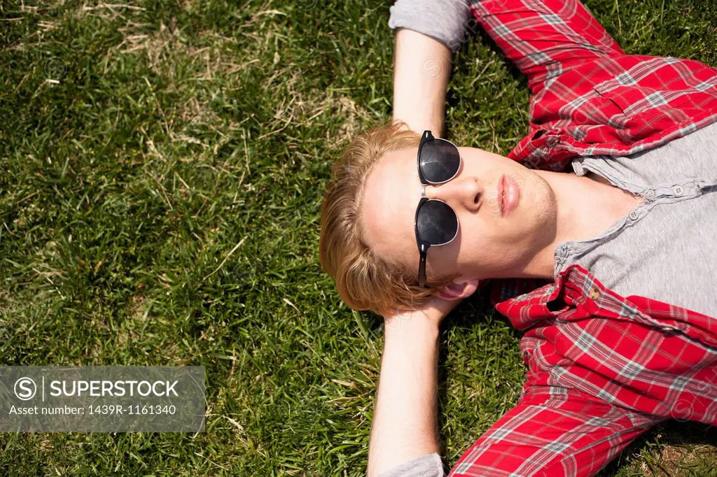 Young man lying down in park