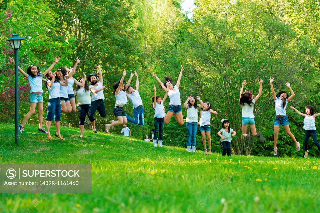 Large group of children jumping in park