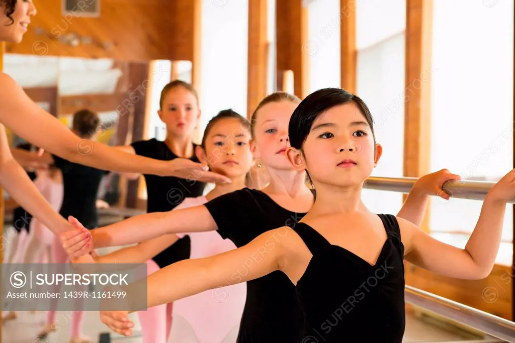Ballerinas practising at the barre in ballet school