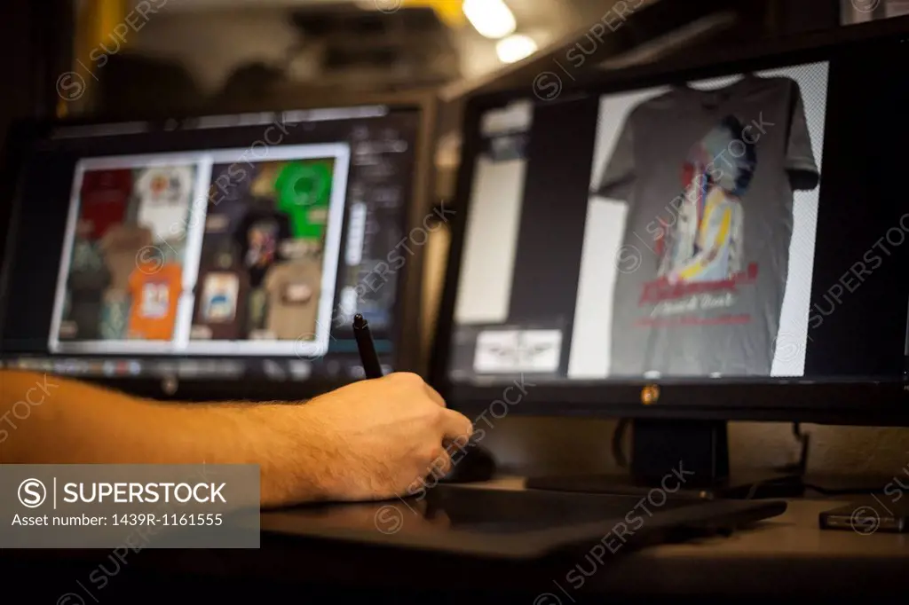 Man using graphic tablet and pen to design t-shirt