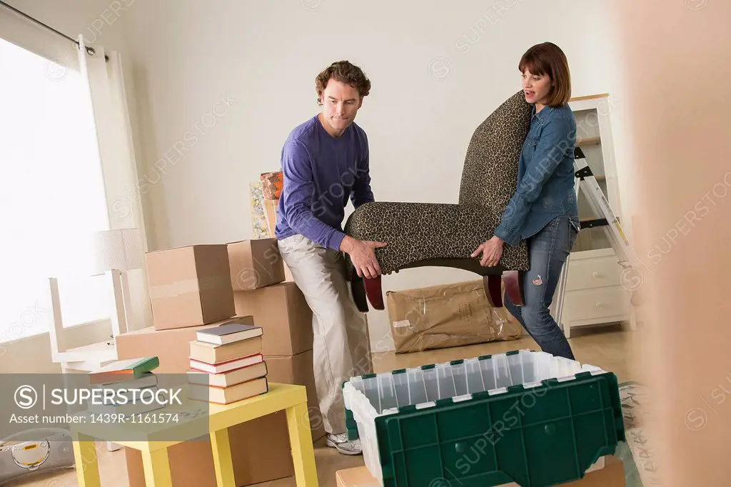 Couple lifting chair in house move
